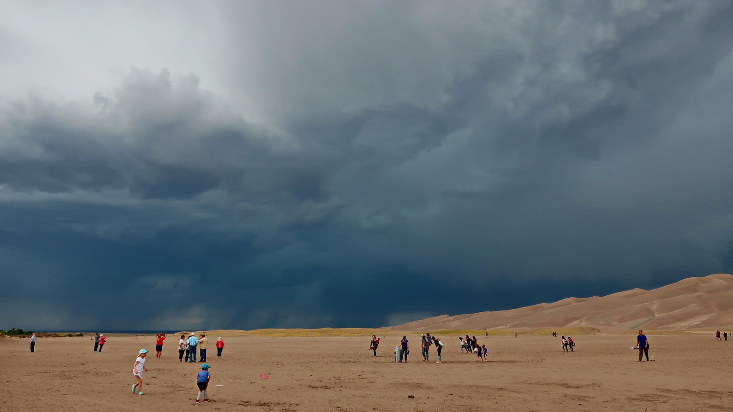 Crowded Great Sand Dunes National Park with black clouds - thunder and lightning are coming!